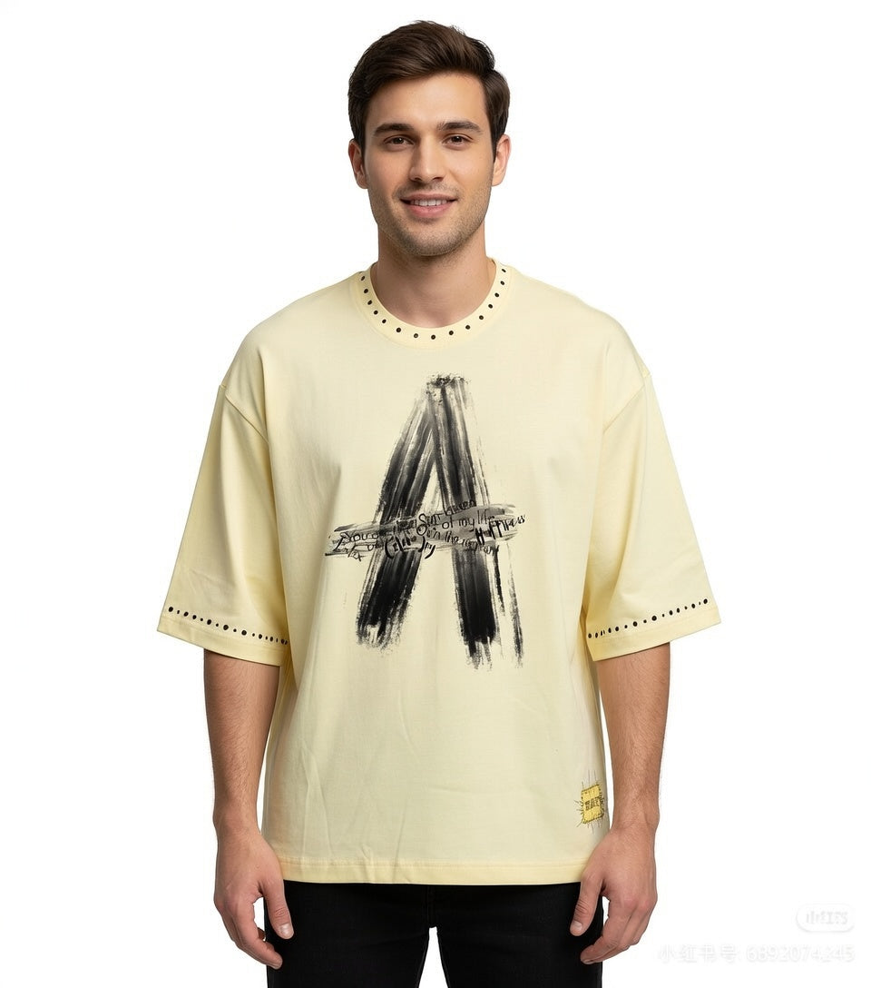 Cream beige JEVPE oversized streetwear T-shirt featuring a brushstroke letter A and rivet details on the front.