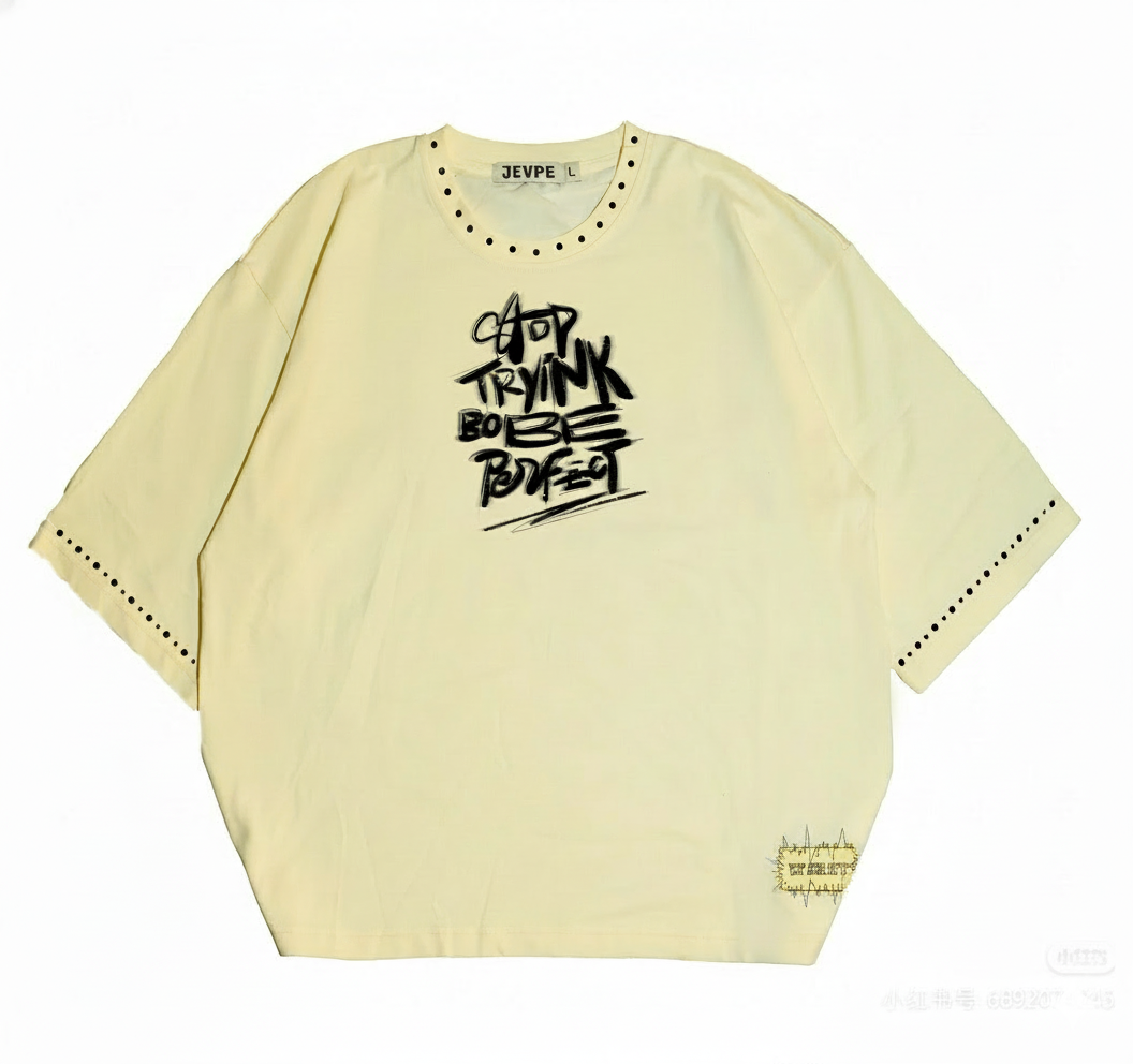 Beige JEVPE graffiti text oversized streetwear T-shirt with rivet details, casual fit, and bold urban design.